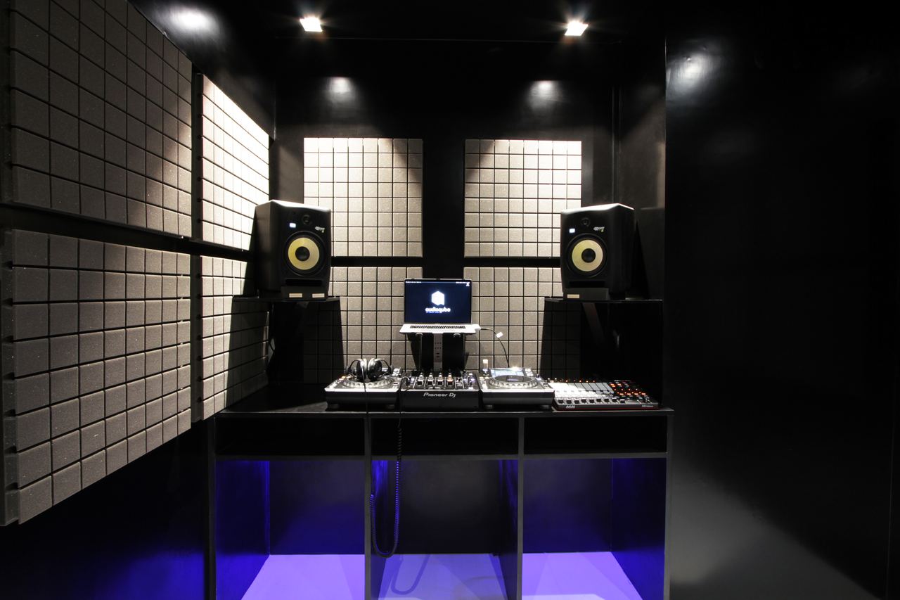 DJ Class 1: decks and mixer centred between two studio monitors against black acoustic panels