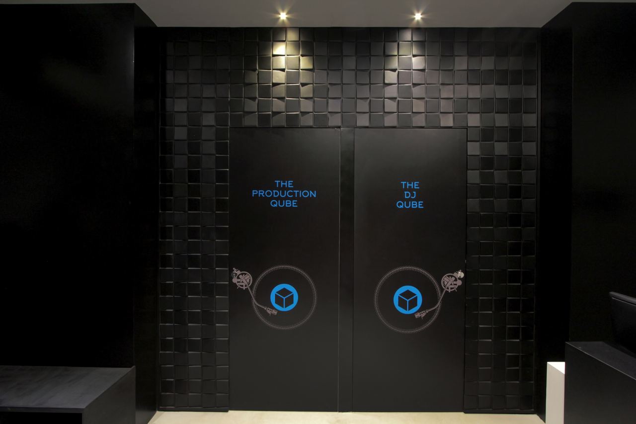 Two black doors labelled The Production Qube and The DJ Qube, each with a glowing blue cube sign